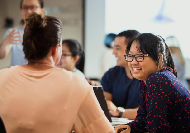 Young professional scientists sitting at a table and talking.