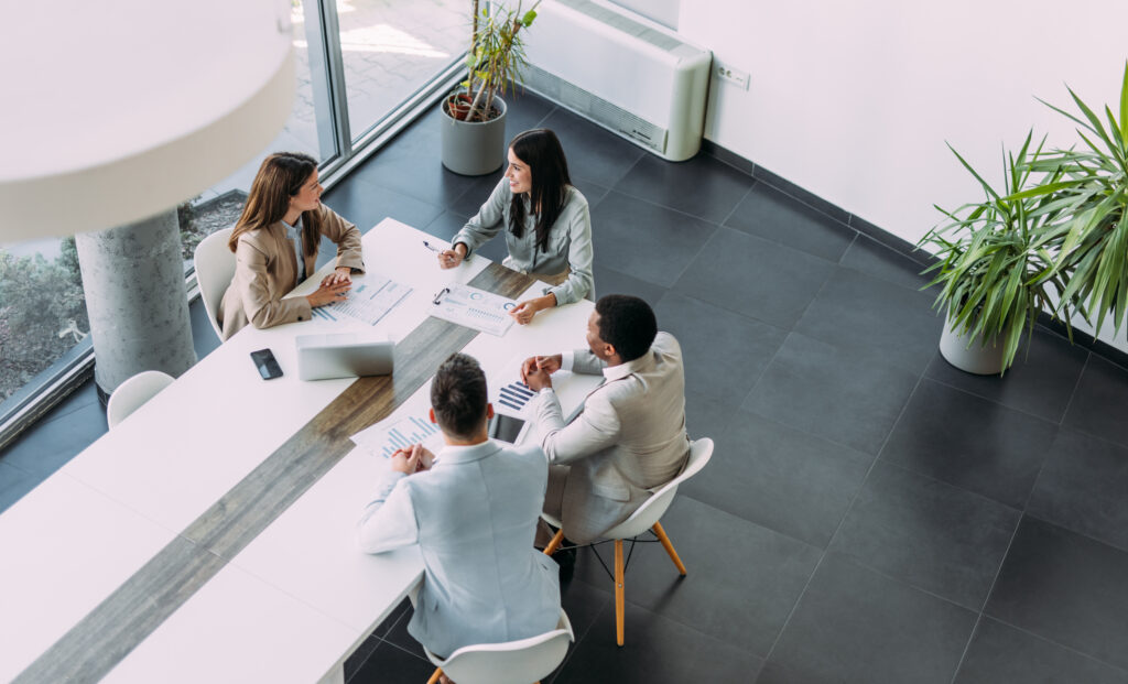 Above view of group of business persons in business meeting. Group of entrepreneurs on meeting in board room. Corporate business team on meeting in the office.