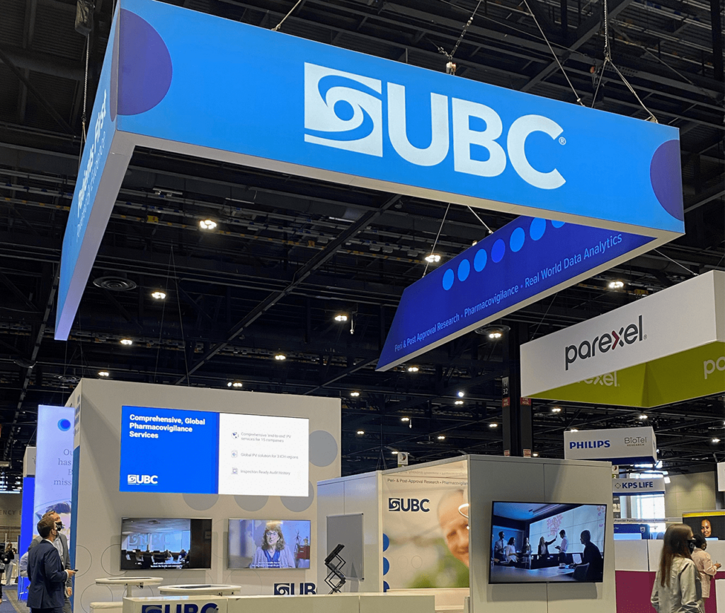 UBC Tradeshow booth showing signage, several presentation screens, private meeting booth and branded tables.