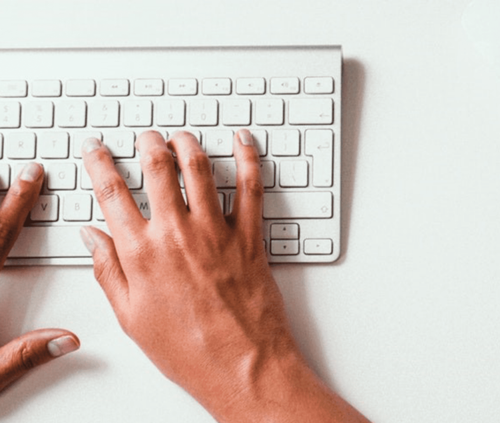 Close up of a person typing on a keyboard.