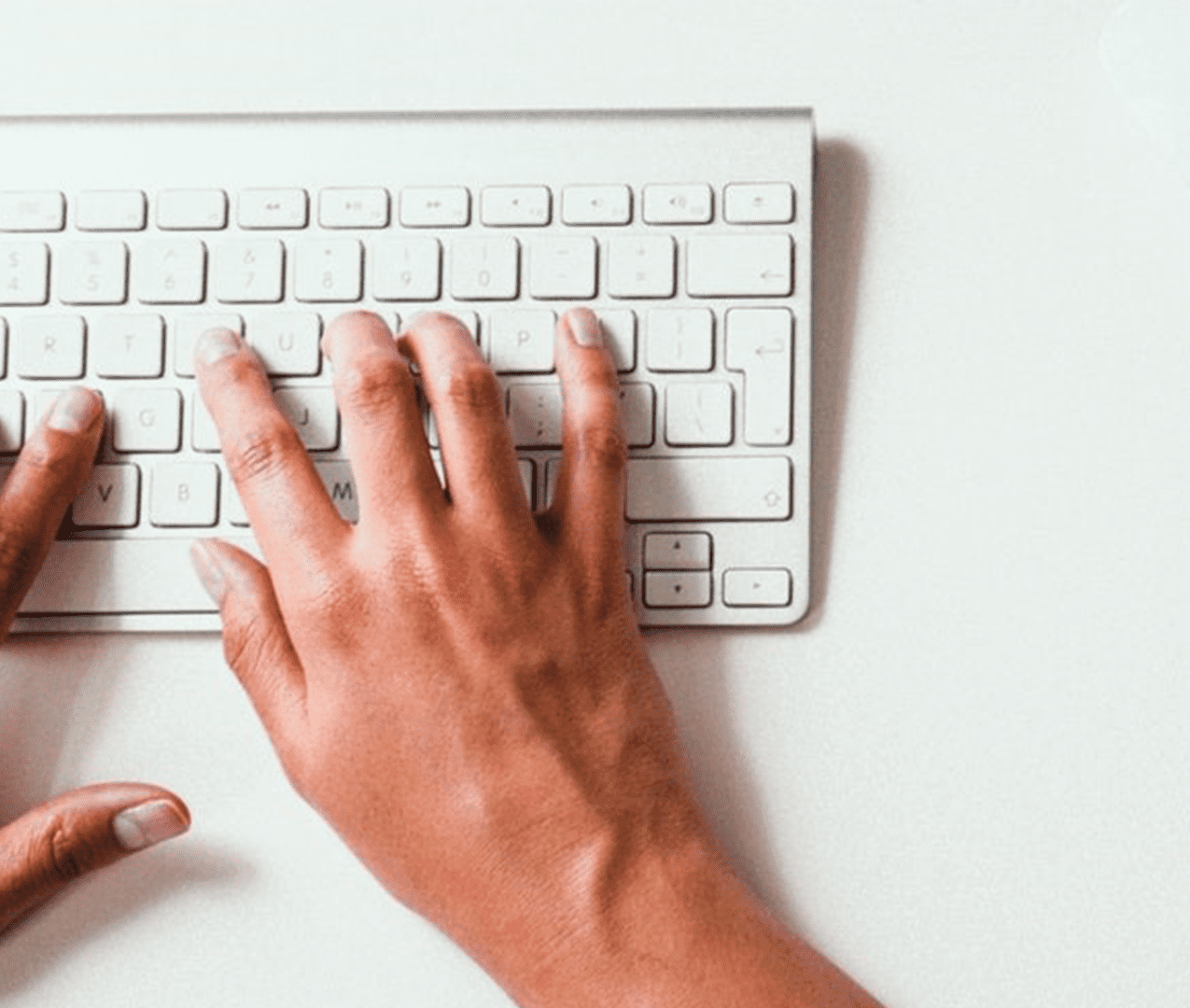 Close up of a person typing on a keyboard.