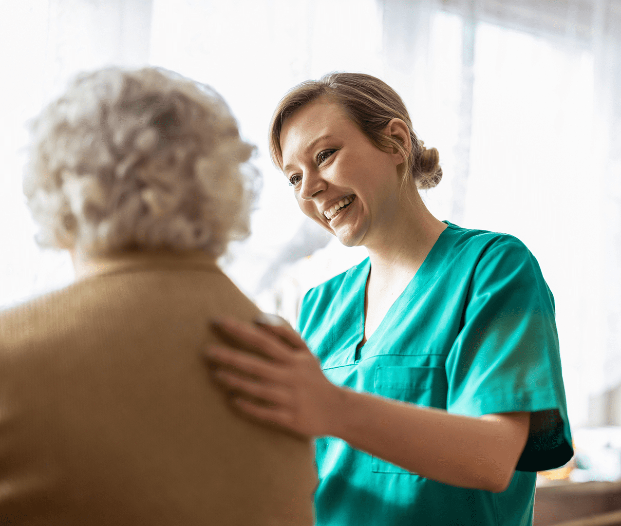 Friendly nurse examining her elderly patient.